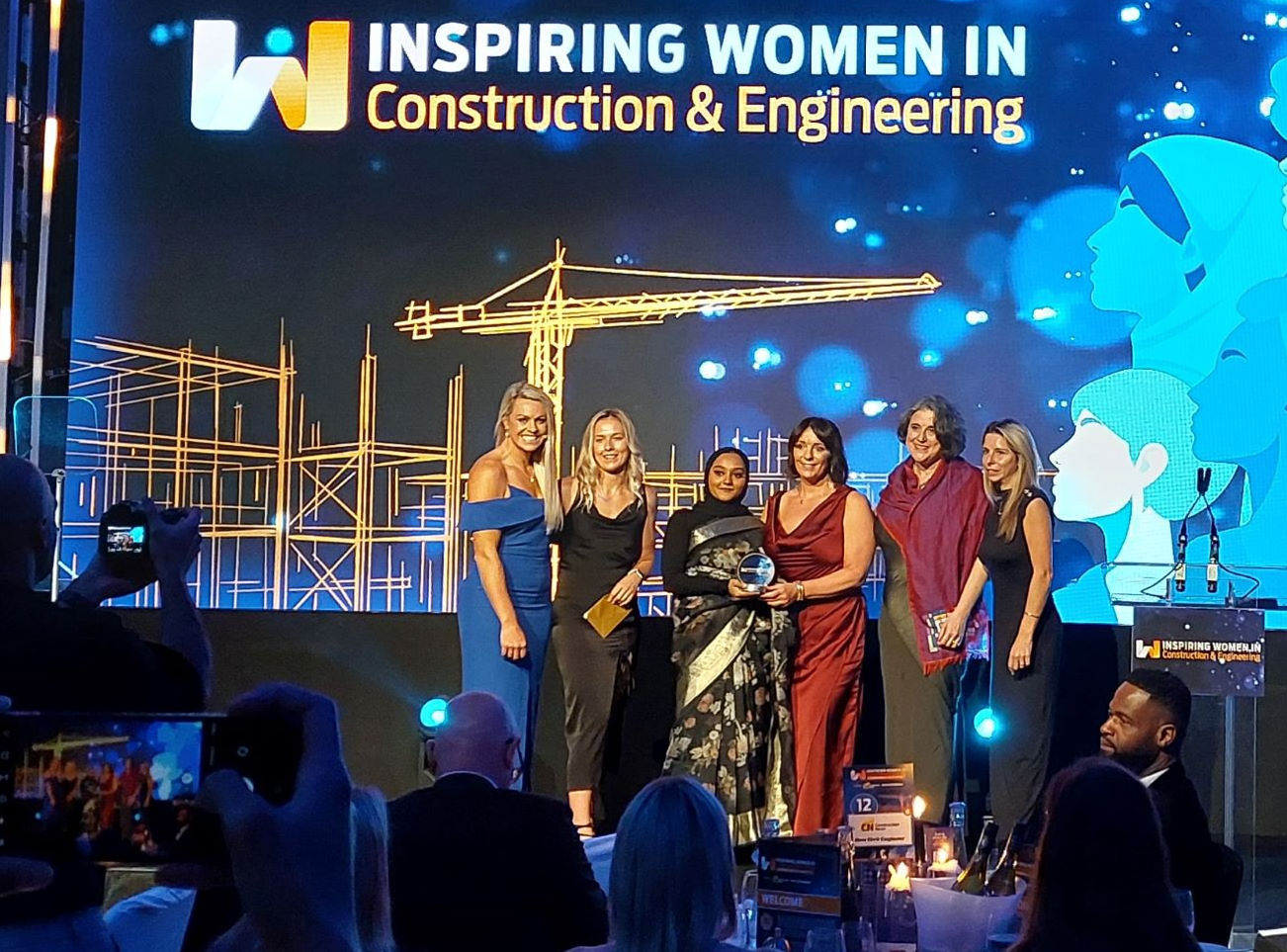 Inspiring Women in Construction awards winning team on stage 3 mid cropped.jpg
